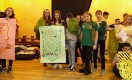 Grupa uczni&oacute;w stanowiąca dom Slytherin ze swoim herbem