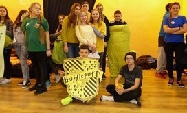 Grupa uczni&oacute;w stanowiąca dom Hufflepuff ze swoim herbem